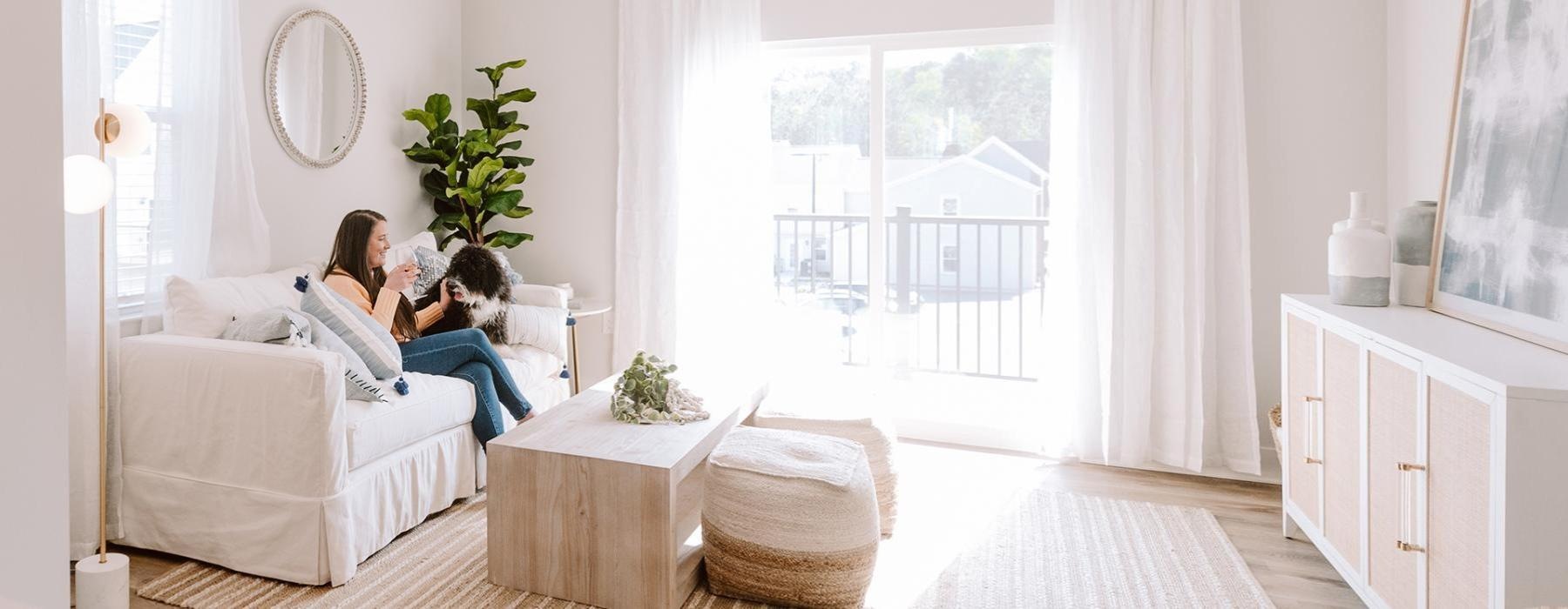 a couple of women sitting on a couch in a room with a large window
